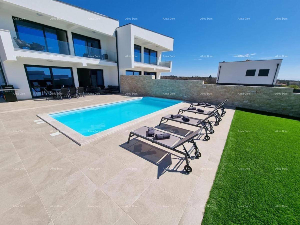 Weitläufiger Außenbereich mit Pool, Liegestühlen und gepflegtem Rasen vor der modernen Villa.