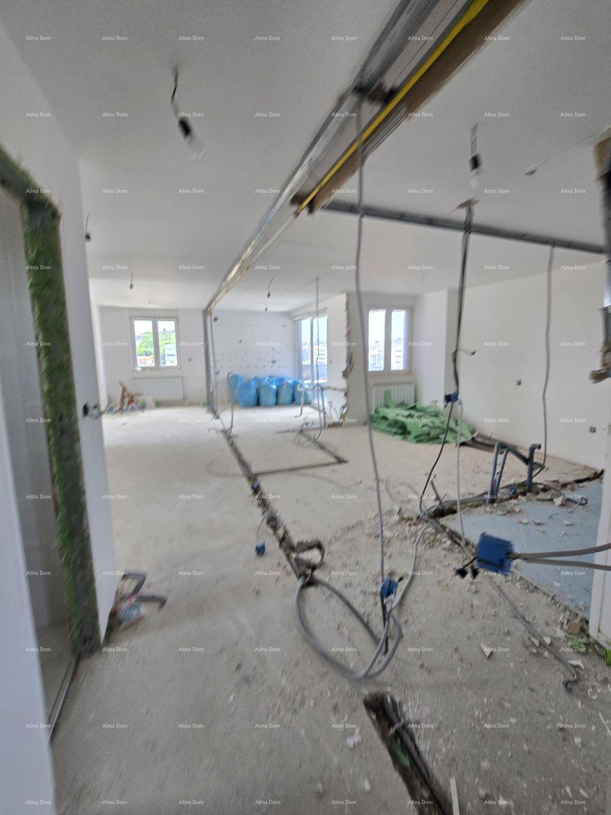 Großer Innenraum im Rohbau mit sichtbaren Installationen und Fenstern.
