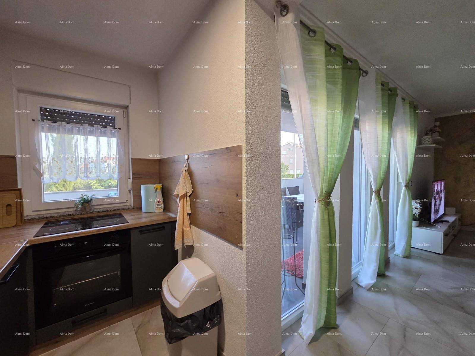 Funktionale Küche mit Holzdetails und Blick auf den Wohnbereich mit Zugang zum Außenbereich.