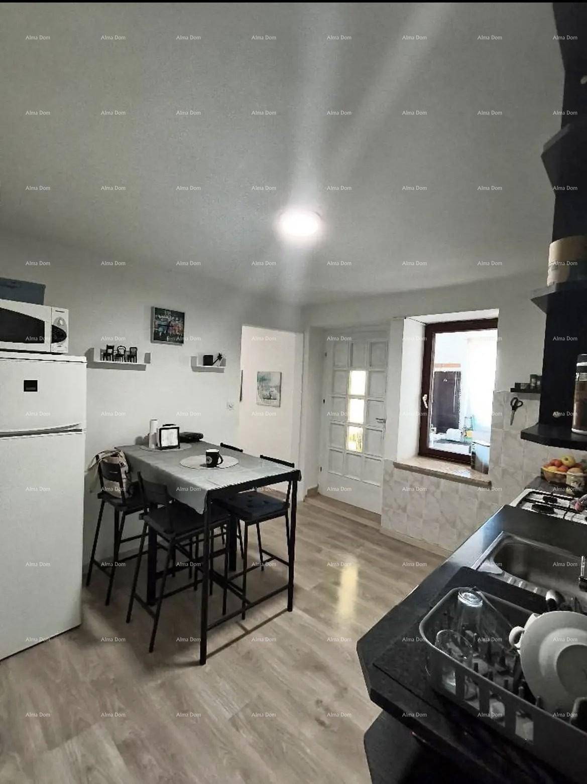 Funktionale Küche mit Essbereich, Kühlschrank und Fenster, praktisch für den Alltag und Mahlzeiten.