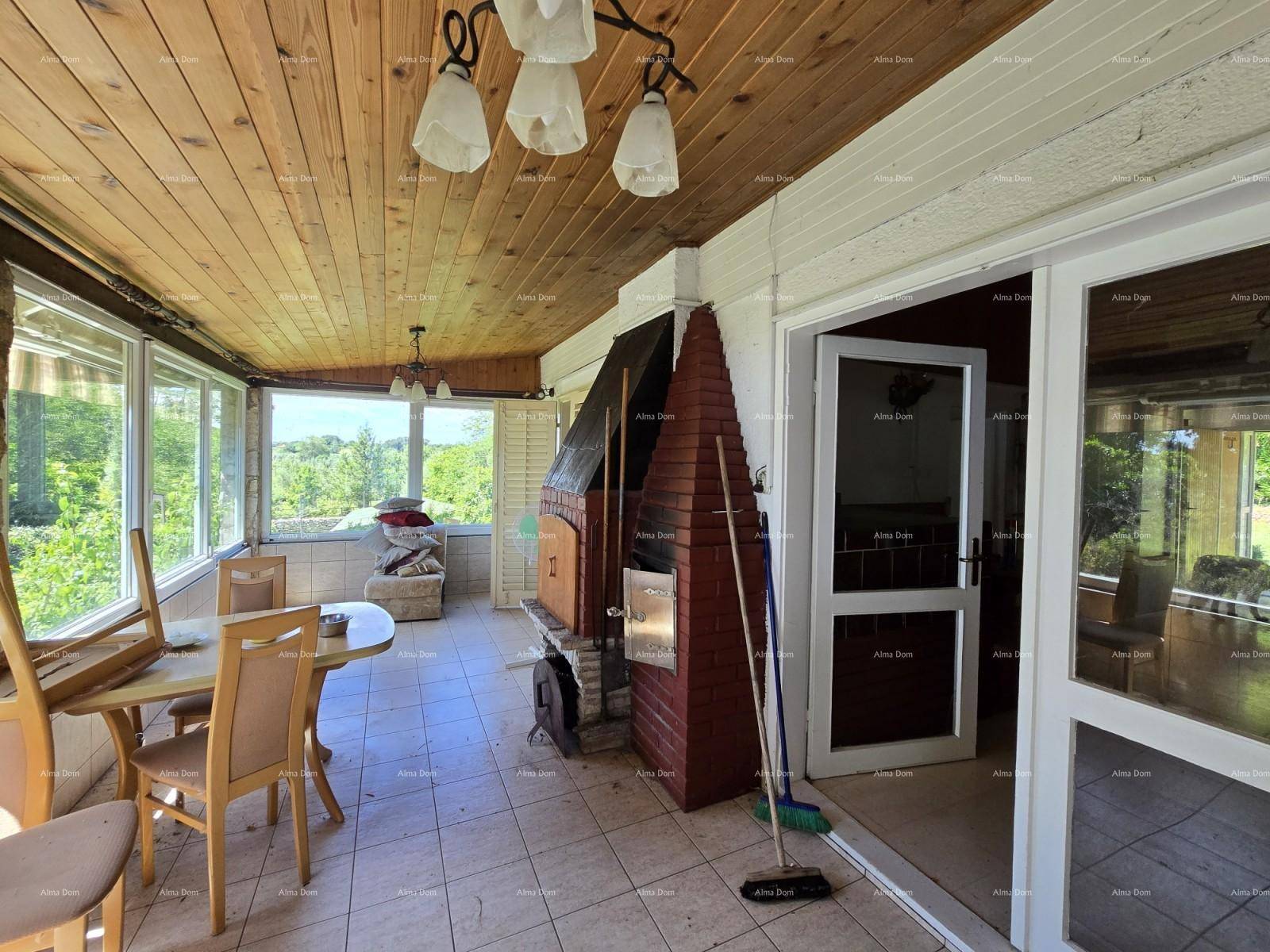 Heller Wintergarten mit Holzdach, Essbereich und gemauertem Grill, ideal für gesellige Stunden.