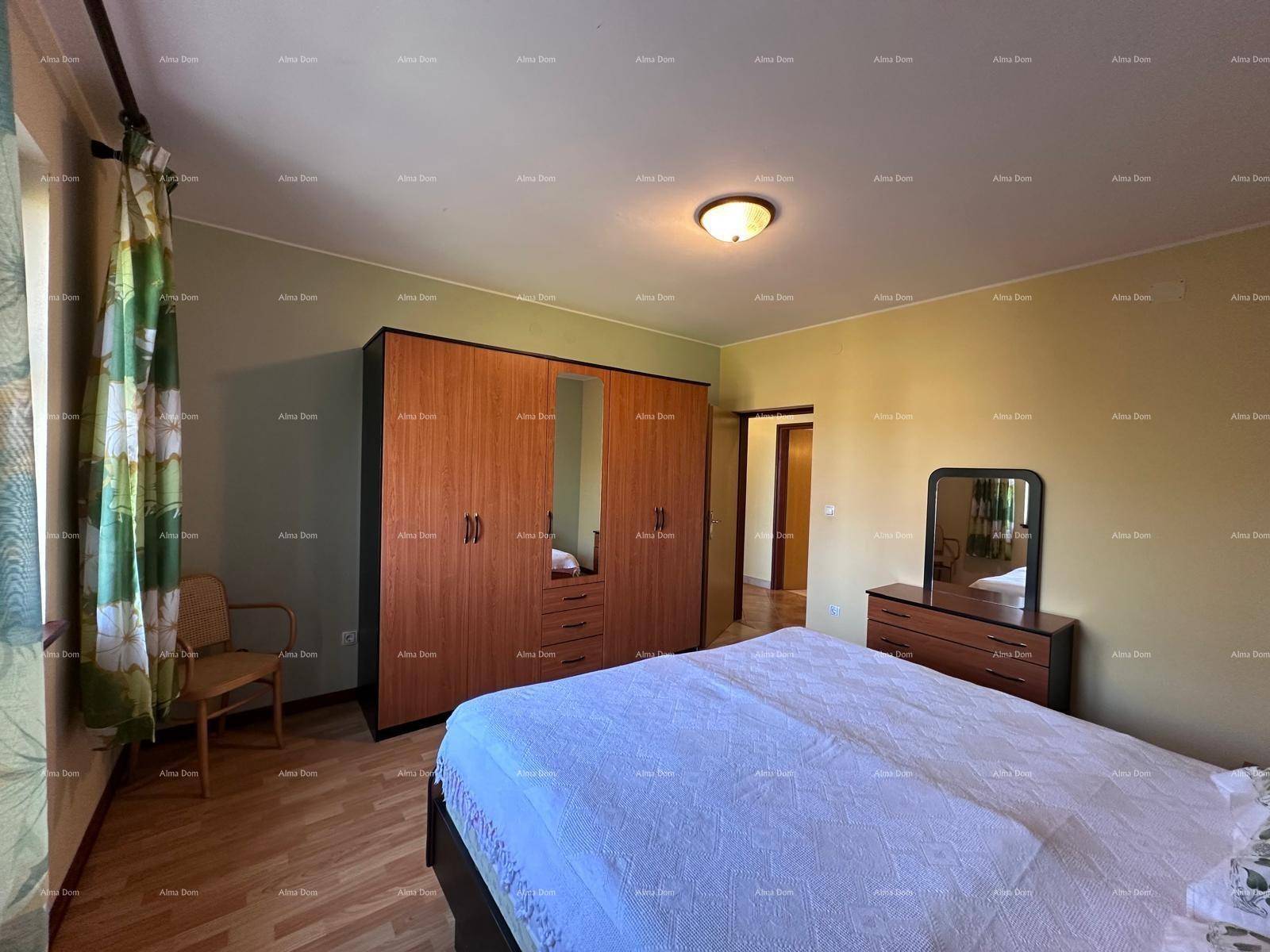 Gemütliches Schlafzimmer mit Doppelbett, Holzschrank und Kommode mit Spiegel.