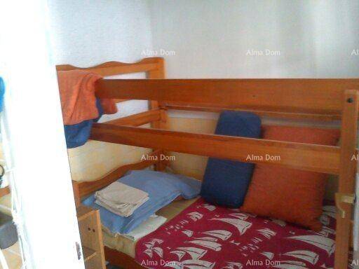 Schlafzimmer mit einem hölzernen Etagenbett und farbigen Kissen.