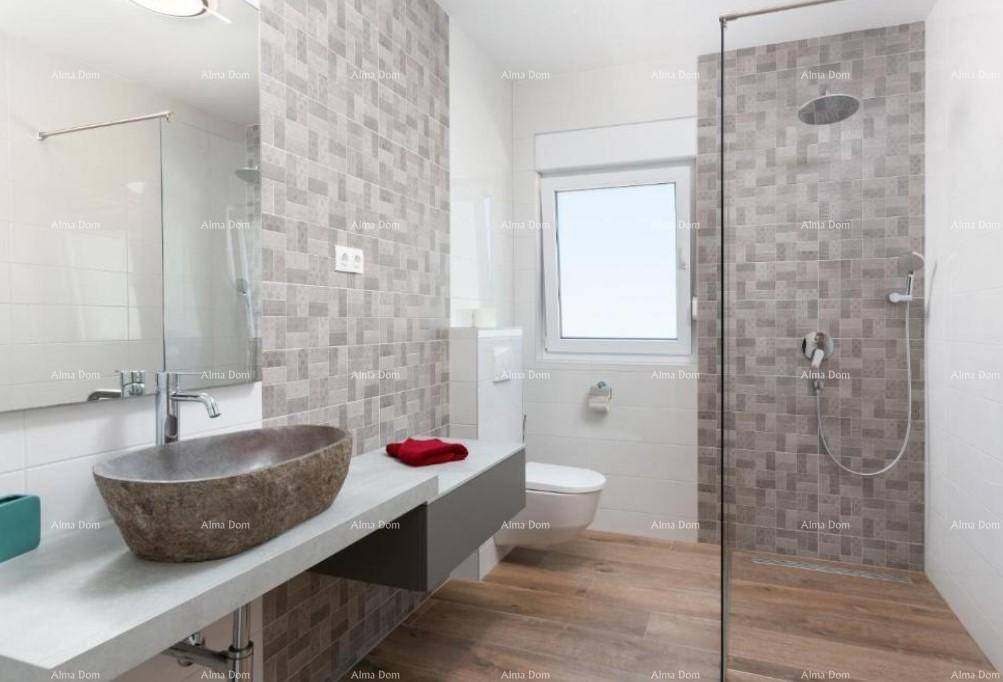 Modernes Badezimmer mit einzigartigem Steinwaschbecken, begehbarer Dusche und grauen Fliesen.
