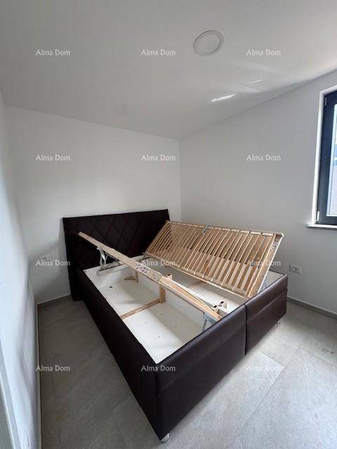 Schlafzimmer mit modernem Bettgestell mit Stauraum, Fliesenboden und Fenster.