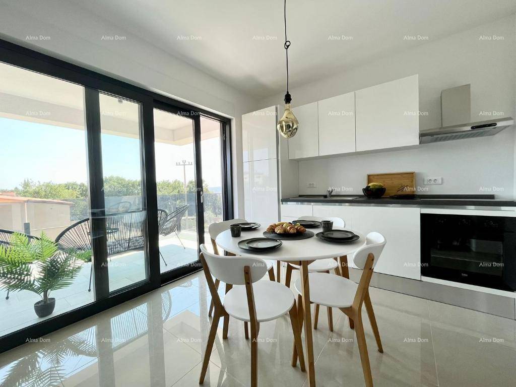 Heller Essbereich mit runden Tisch und moderner Küche, Zugang zum Balkon.