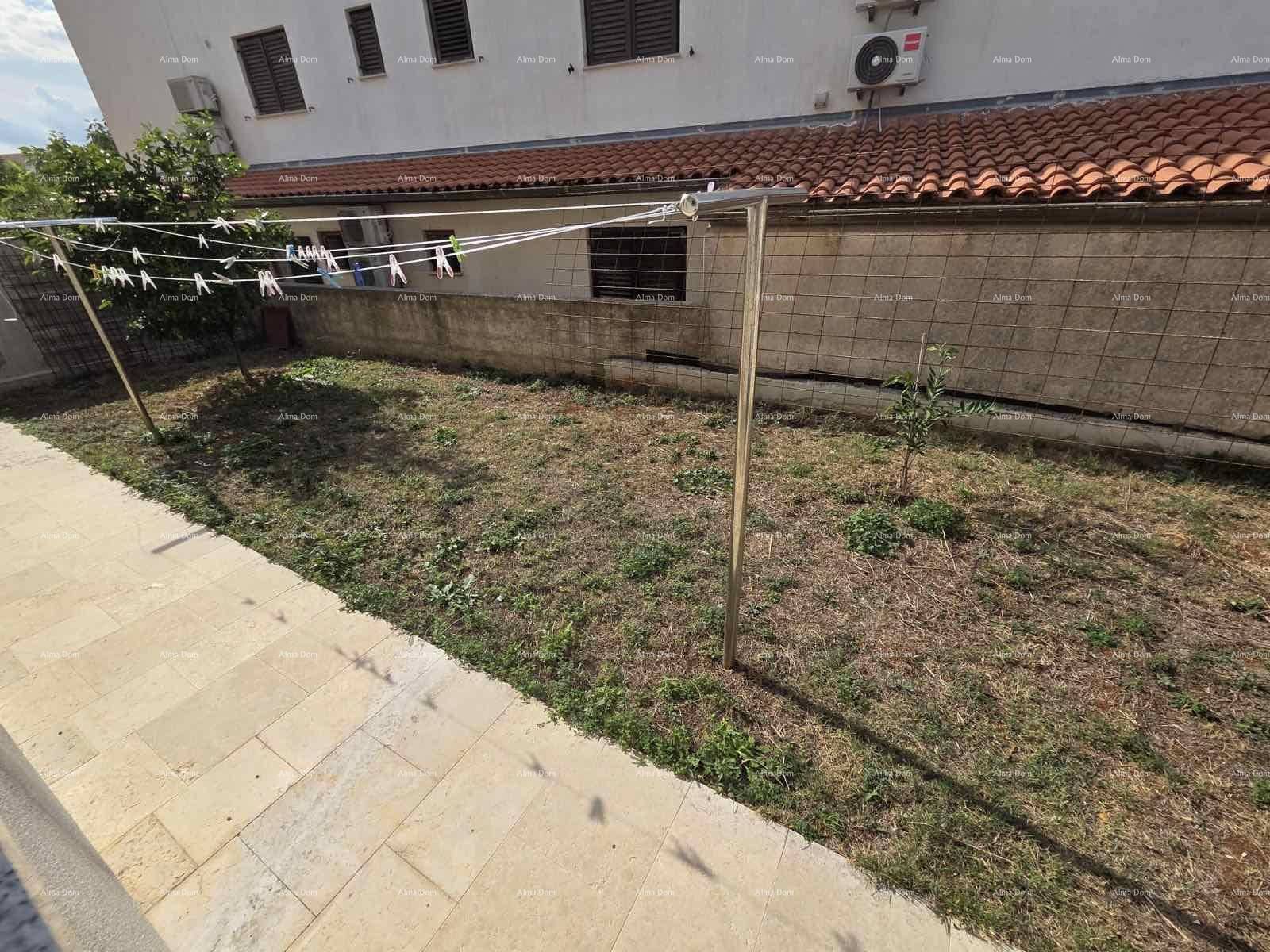 Kleiner Gartenbereich mit Wäscheleine und einfacher Bepflanzung neben dem Gebäude.