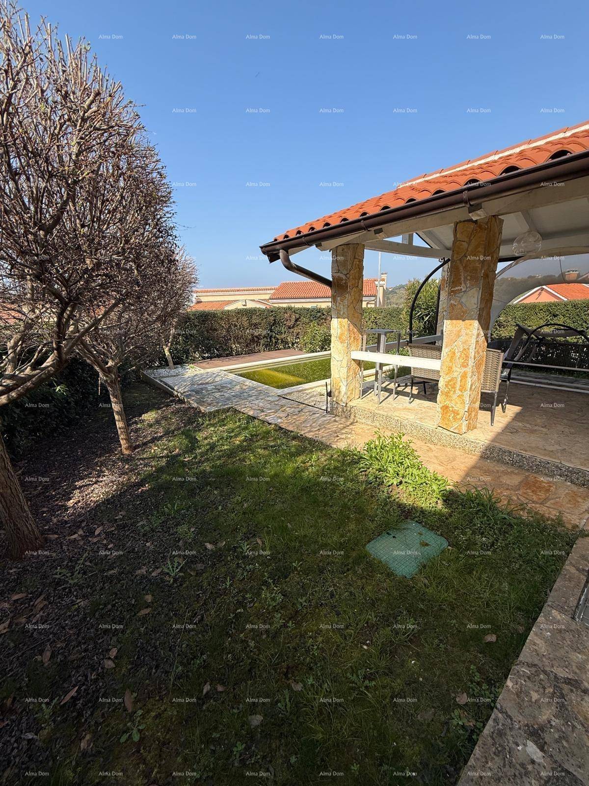 Gepflegter Gartenbereich mit überdachter Terrasse, kleinem Teich und Sitzgelegenheiten im Freien.