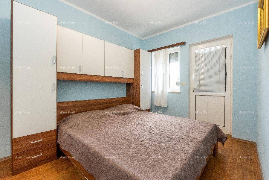 Schlafzimmer mit Einbauschränken, Doppelbett und Zugang zu einem Balkon oder Terrasse.
