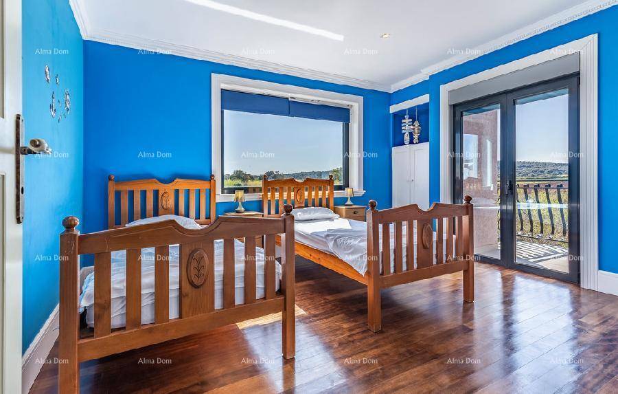 Helles Schlafzimmer mit zwei Einzelbetten, blauen Wänden und Balkonzugang.