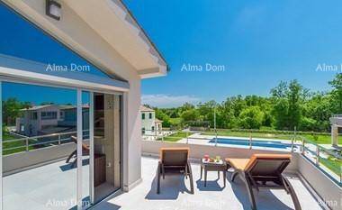 Geräumiger Balkon mit Sonnenliegen und Blick auf den Poolbereich und die grüne Umgebung.
