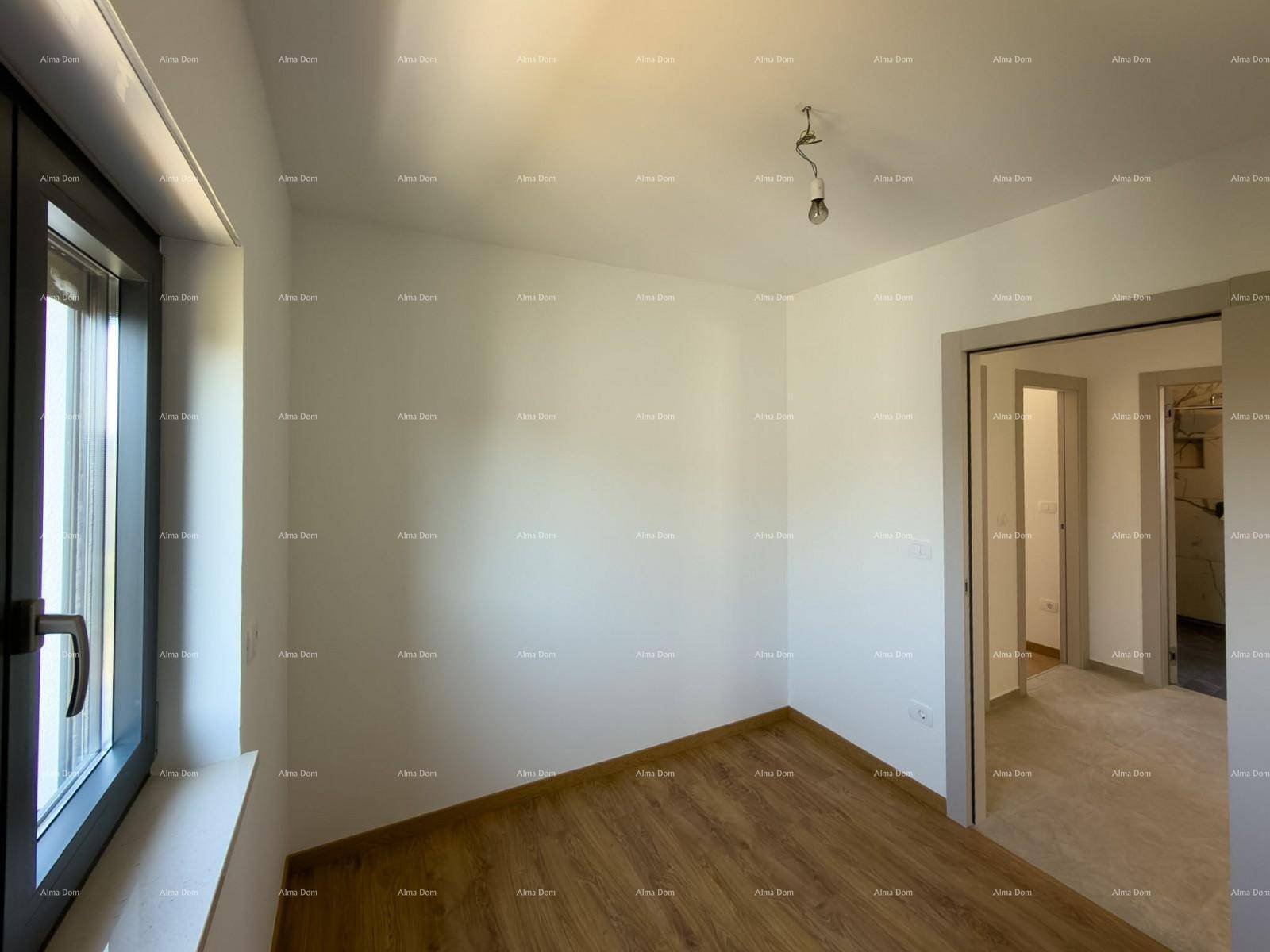 Schlafzimmer mit Holzfußboden und viel Tageslicht durch das große Fenster.