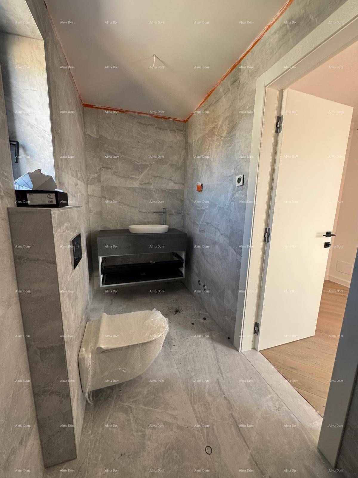 Geräumiges Badezimmer mit modernen grauen Fliesen, wandhängendem WC und Waschtisch.