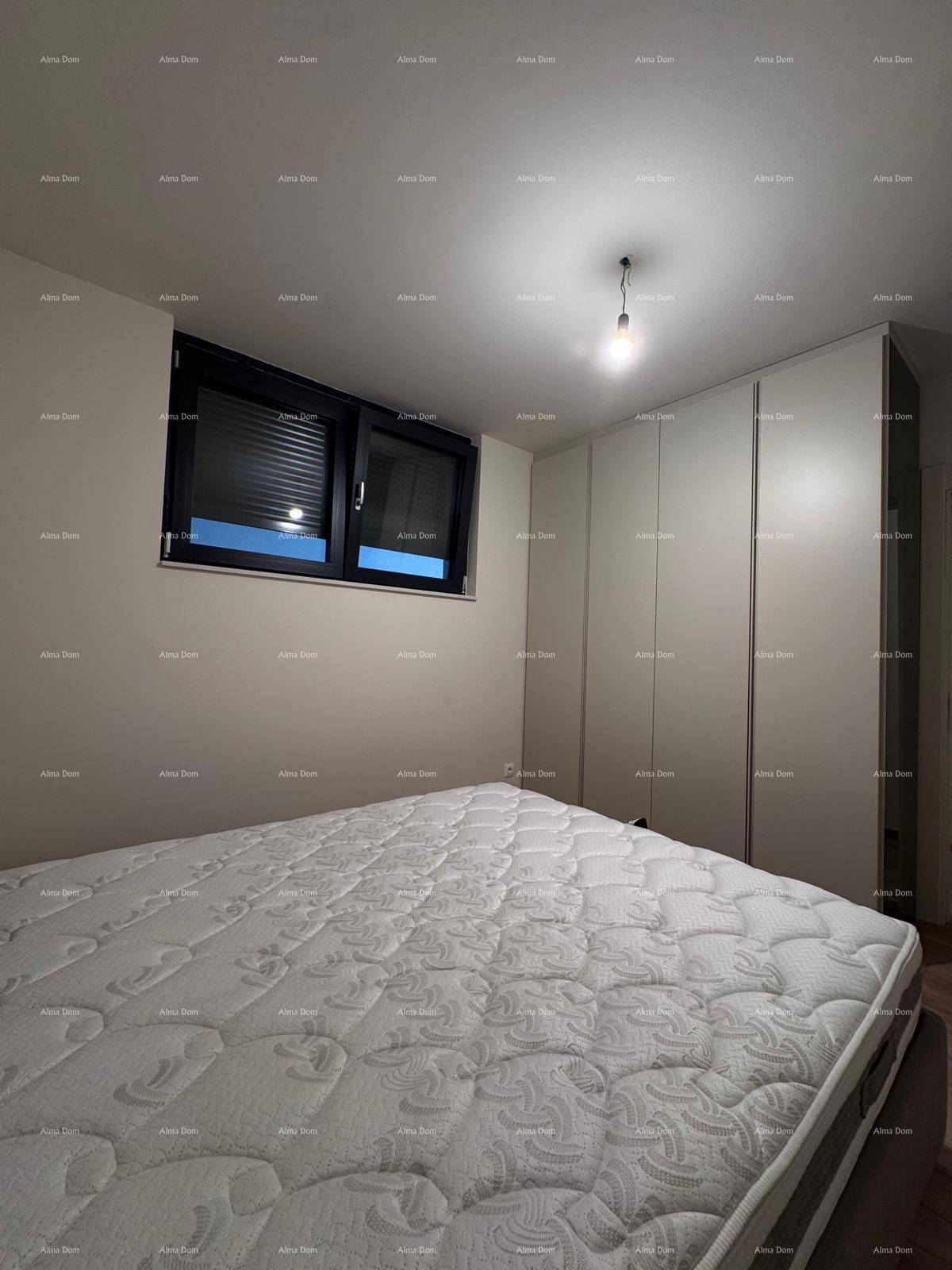 Schlafzimmer mit Holzboden, bequemer Matratze und Fenster mit Rollläden für Privatsphäre.