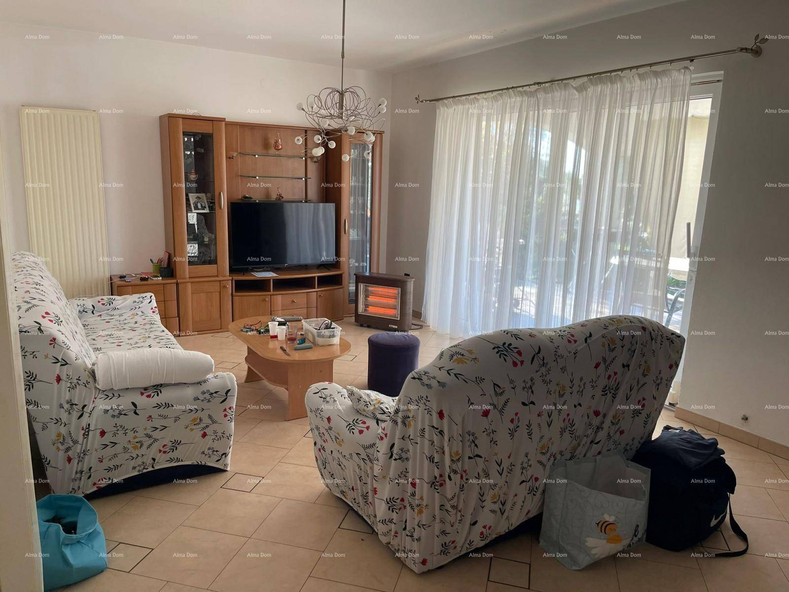 Gemütliches Wohnzimmer mit Fliesenboden, zwei Sofas, Couchtisch und einem TV-Möbel, hell und geräumig.