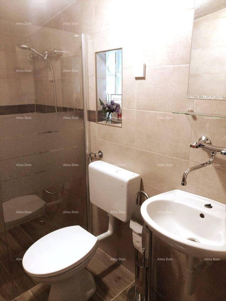 Modernes Badezimmer mit Duschkabine, WC und Waschbecken, hell gefliest und gut beleuchtet.