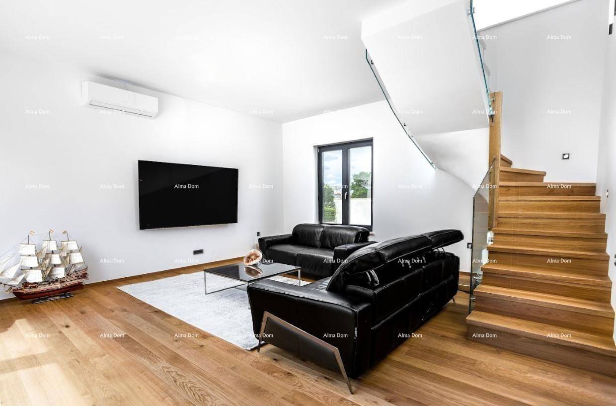 Helles Wohnzimmer mit Holzboden, schwarzem Sofa und moderner Holztreppe mit Glasgeländer.
