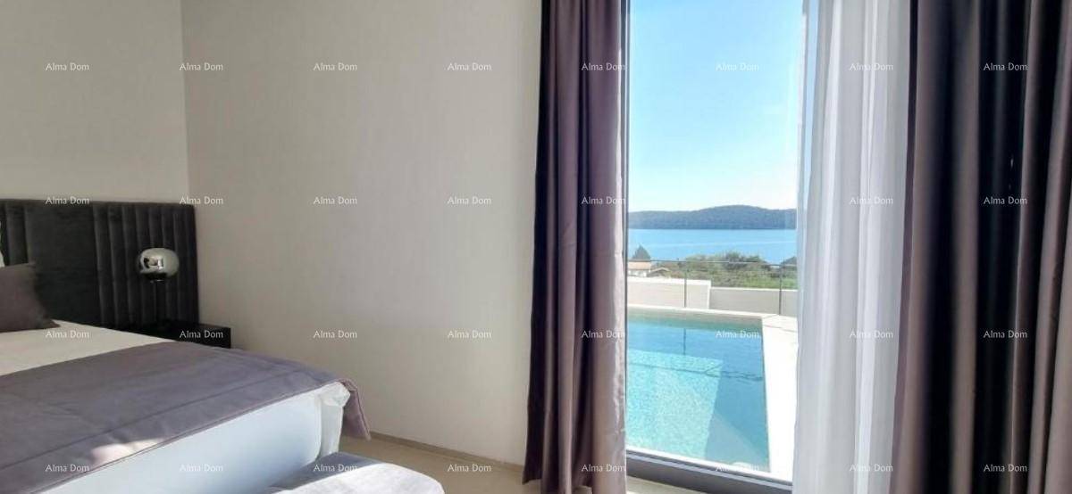 Schlafzimmer mit bequemem Bett und großem Fenster, das einen herrlichen Blick auf das Meer und den Pool bietet.