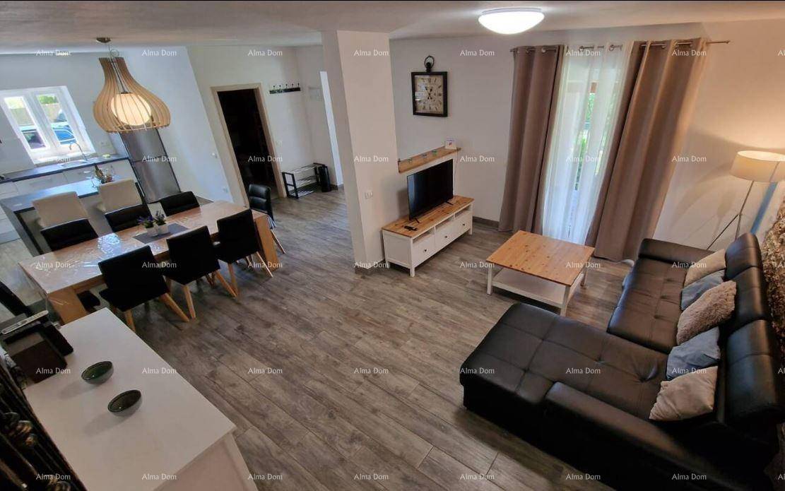 Offener Wohn- und Essbereich mit modernem Sofa, Esstisch und Blick in die Küche.