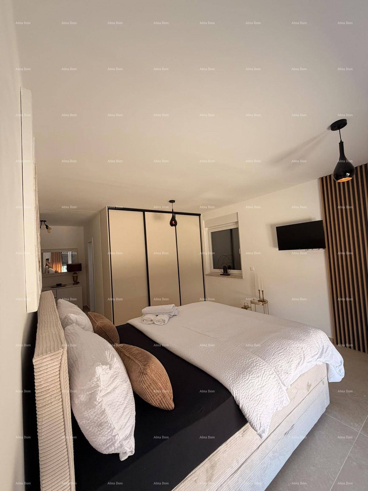 Schlafzimmer mit Doppelbett, Schiebetürenschrank und Wandfernseher in modernem Stil.