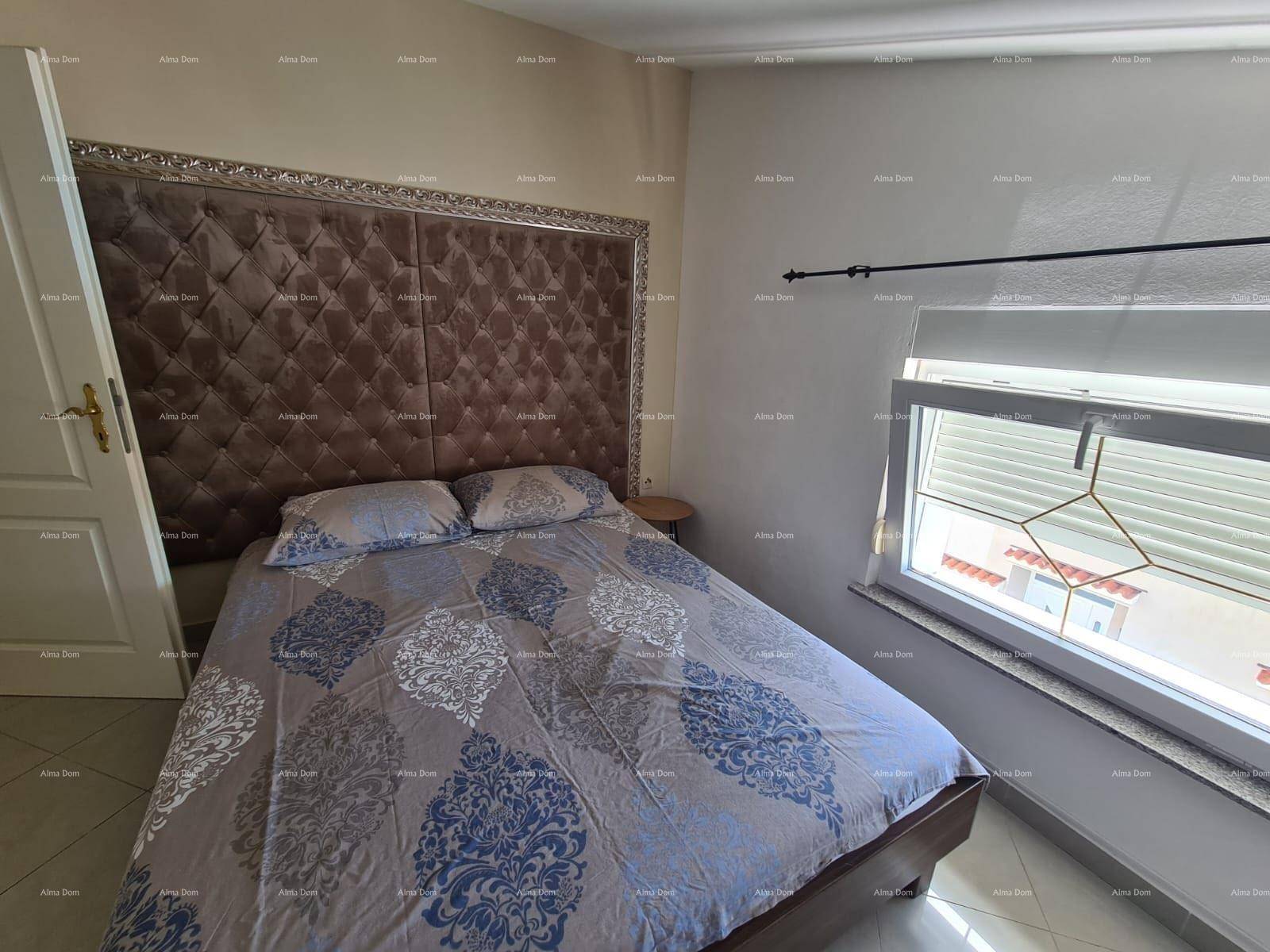Schlafzimmer mit großem Bett, gepolstertem Kopfteil und Fenster mit Blick nach draußen.