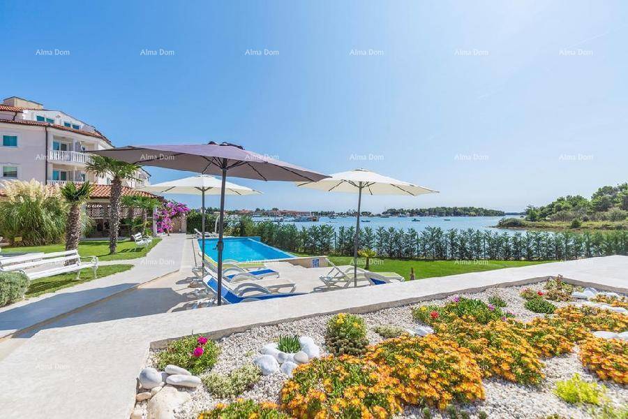 Mediterraner Garten mit bunten Blumenbeeten, großem Pool und Panoramablick auf die Küste.