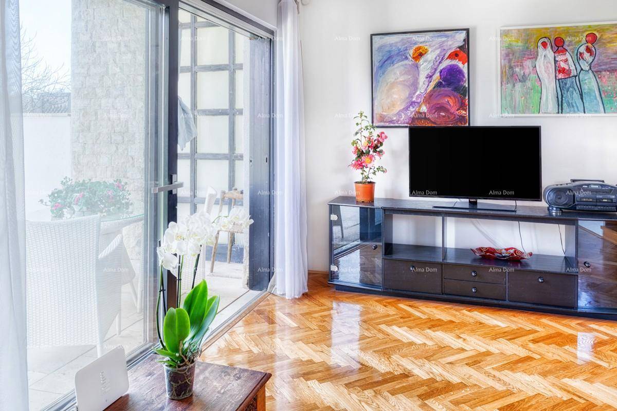 Wohnzimmer mit Fernseher, Holzboden und großen Schiebetüren zur Terrasse.