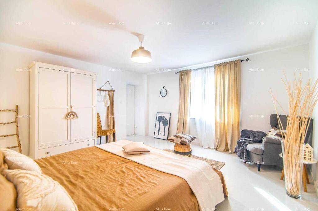 Helles Schlafzimmer mit Doppelbett, weißem Kleiderschrank und großen Fenstern für viel Tageslicht.