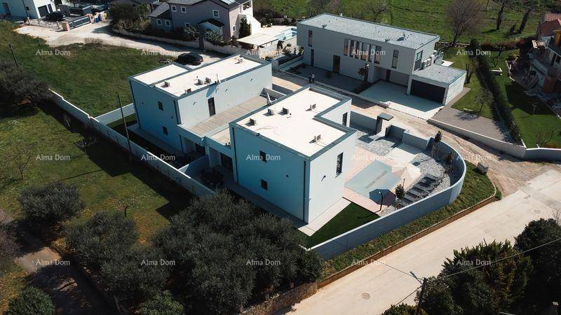 Luftaufnahme eines modernen Wohnkomplexes mit Flachdächern und umliegender Landschaft.