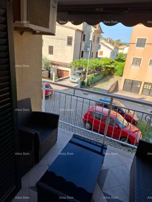 Balkon mit Sitzgelegenheiten und Blick auf die Straße und umliegende Gebäude in der Nachbarschaft.