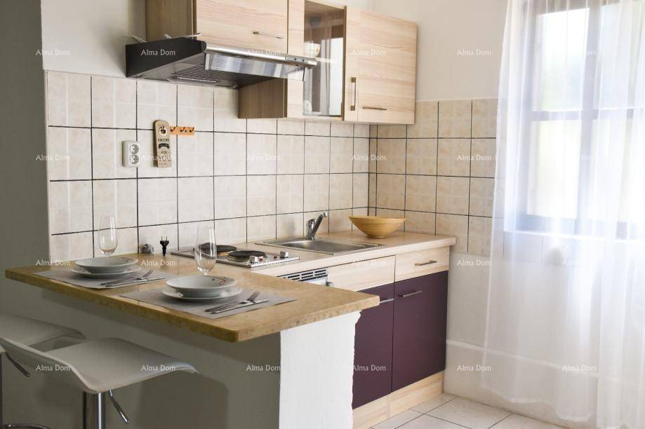 Funktionale Küchenzeile mit Frühstücksbar, Kochfeld und Spüle, ideal für kleine Räume.