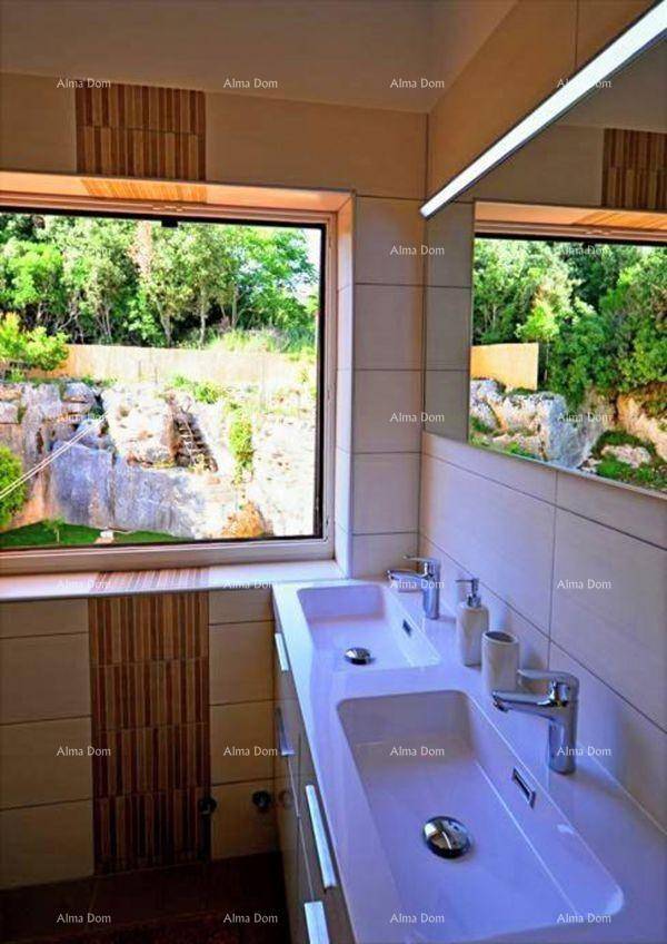 Badezimmer mit Doppelwaschbecken und großem Fenster, das einen Blick auf die grüne Landschaft bietet.