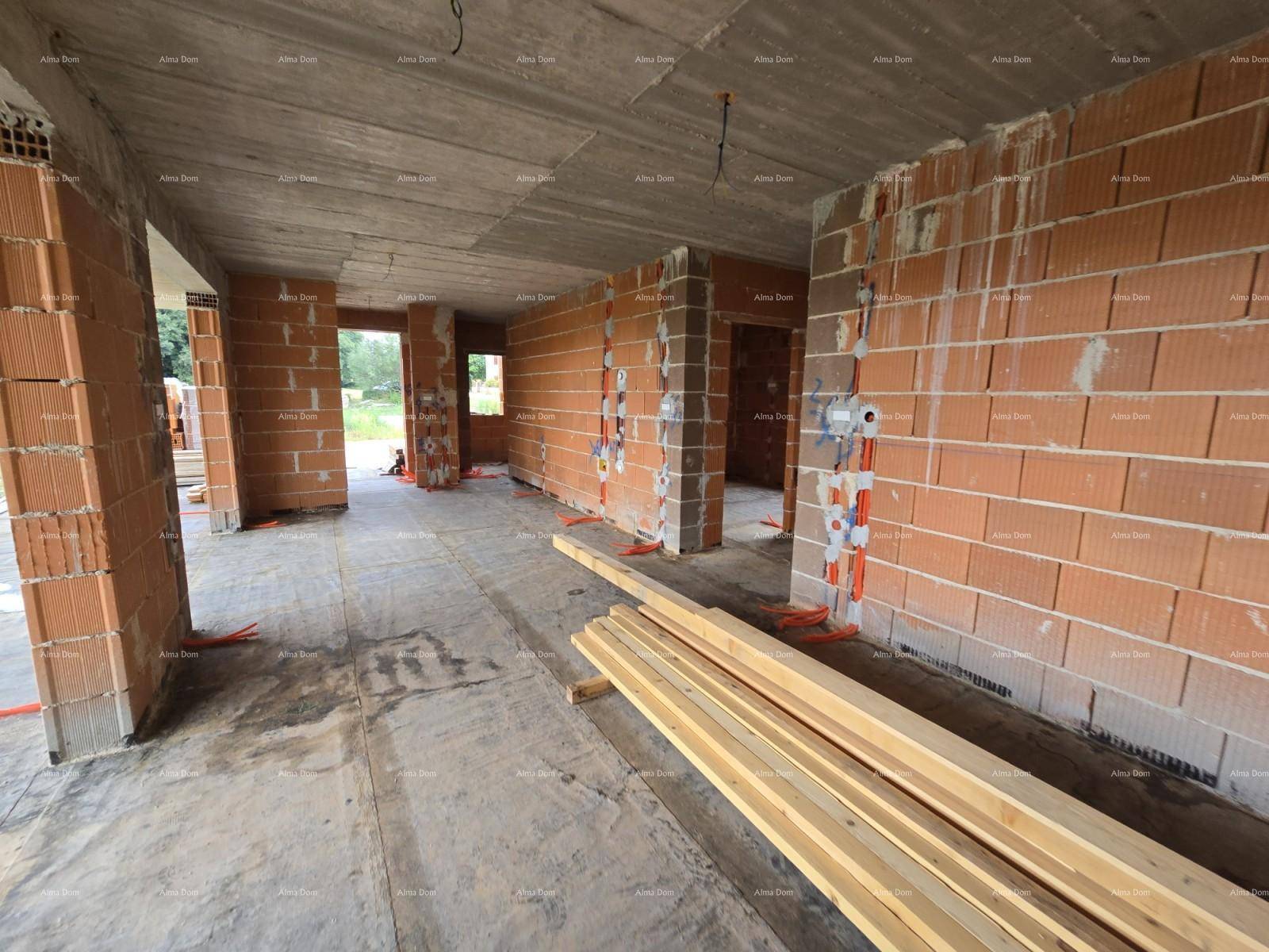 Großer offener Raum im Rohbau mit Ziegelwänden, Türöffnungen und vorbereiteten Elektroinstallationen.