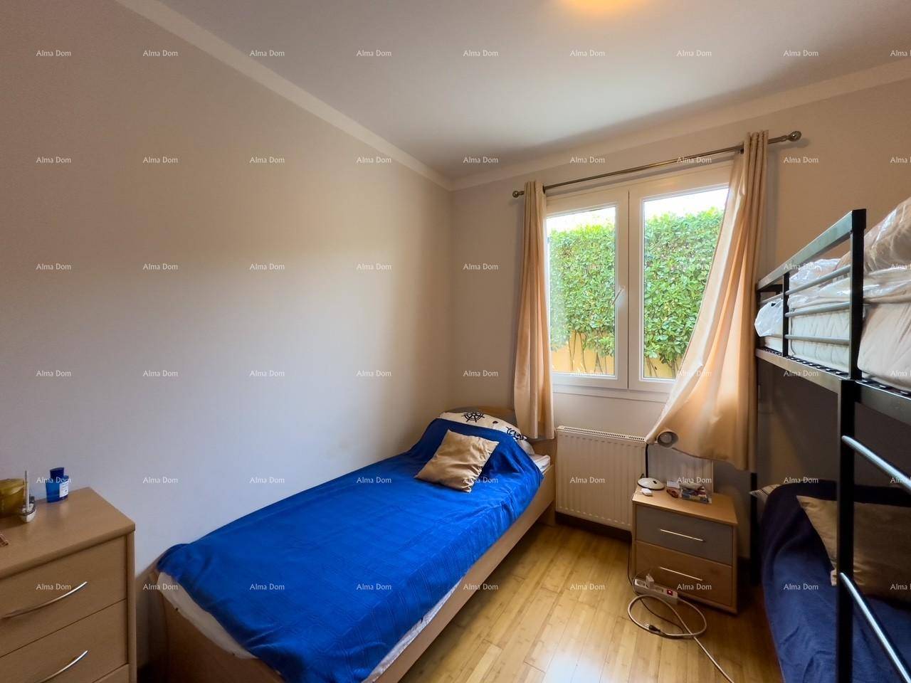 Helles Kinderzimmer mit Einzelbett, Holzboden und Fenster mit Blick auf die Hecke, freundlich gestaltet.
