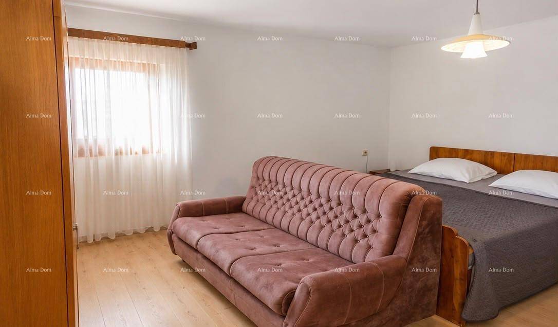 Gemütliches Schlafzimmer mit einem Bett, einem Sofa und hellem Holzfußboden.
