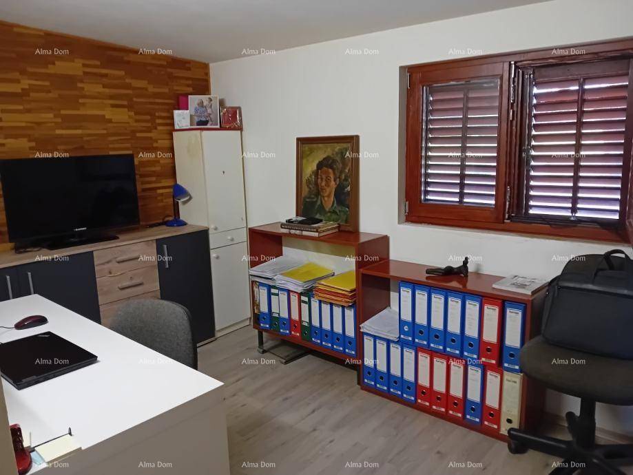 Funktionales Büro mit Schreibtisch, Stauraum und einem Fenster mit Holzjalousien.