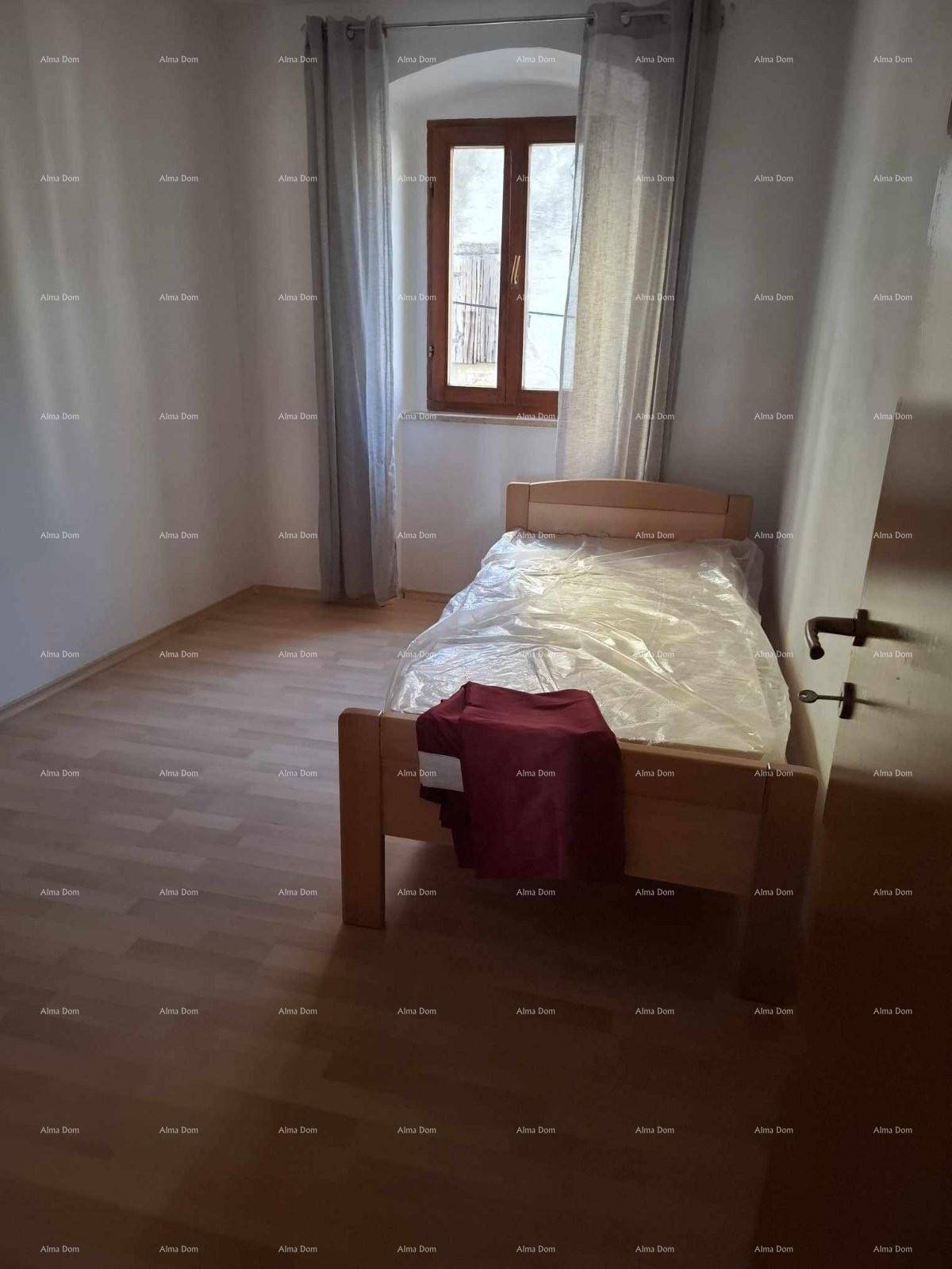 Helles Schlafzimmer mit Einzelbett, Laminatboden und einem Fenster mit Vorhängen.