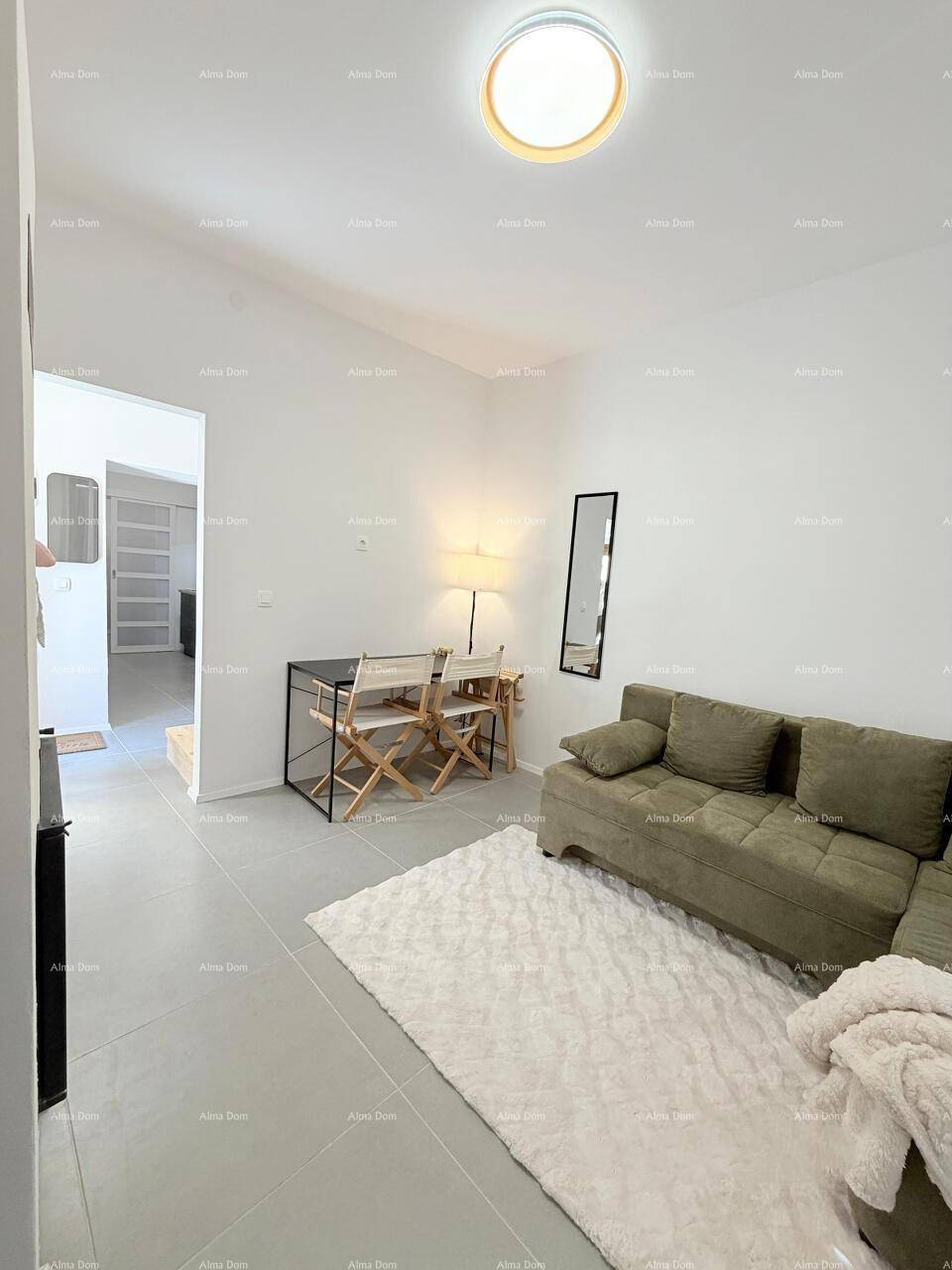 Heller Wohnbereich mit bequemem Sofa, kleinem Esstisch und modernem Fliesenboden, sehr einladend.