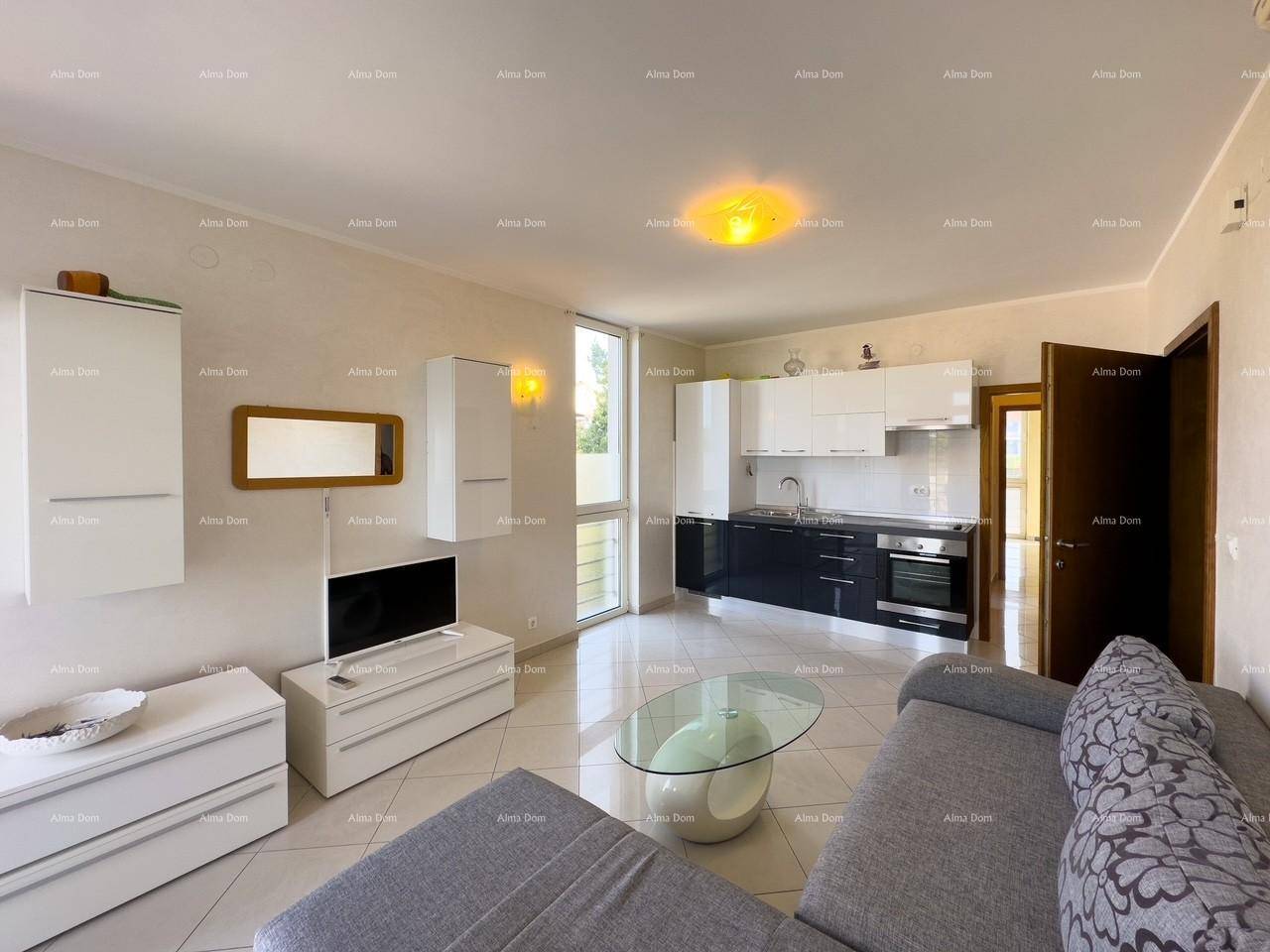 Offener Wohnbereich mit integrierter Küche, modernem Sofa und hellen Fliesen.