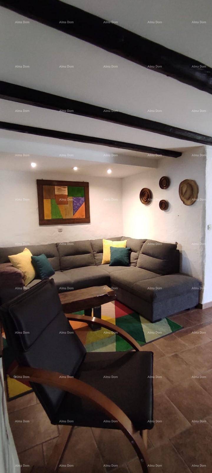 Heller Wohnbereich mit großem Ecksofa, farbenfrohem Teppich und traditioneller Wanddekoration.