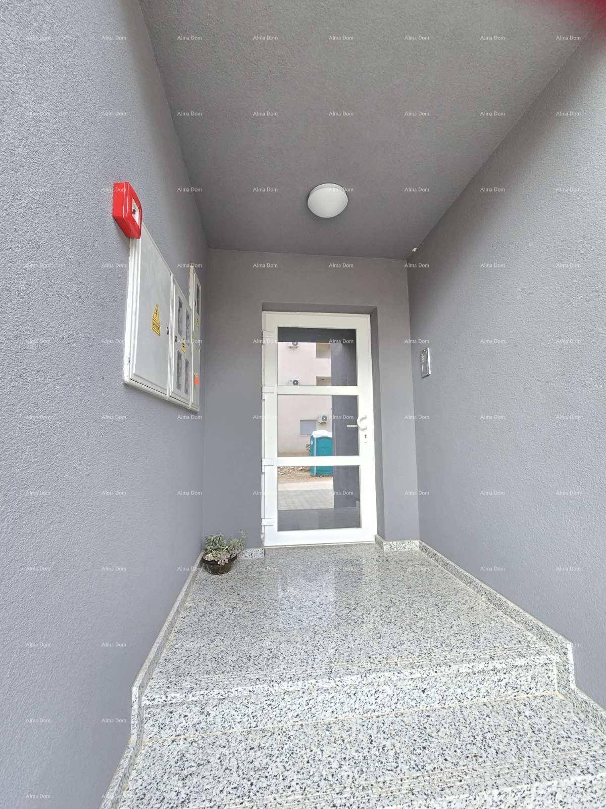 Eingangsbereich eines modernen Gebäudes mit Granitboden und einer Sicherheitstür.