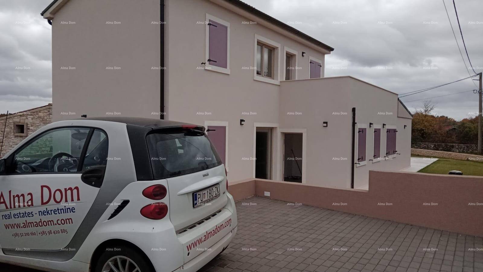 Hausfassade mit lila Fensterläden, gepflasterter Auffahrt und geparktem Smart.