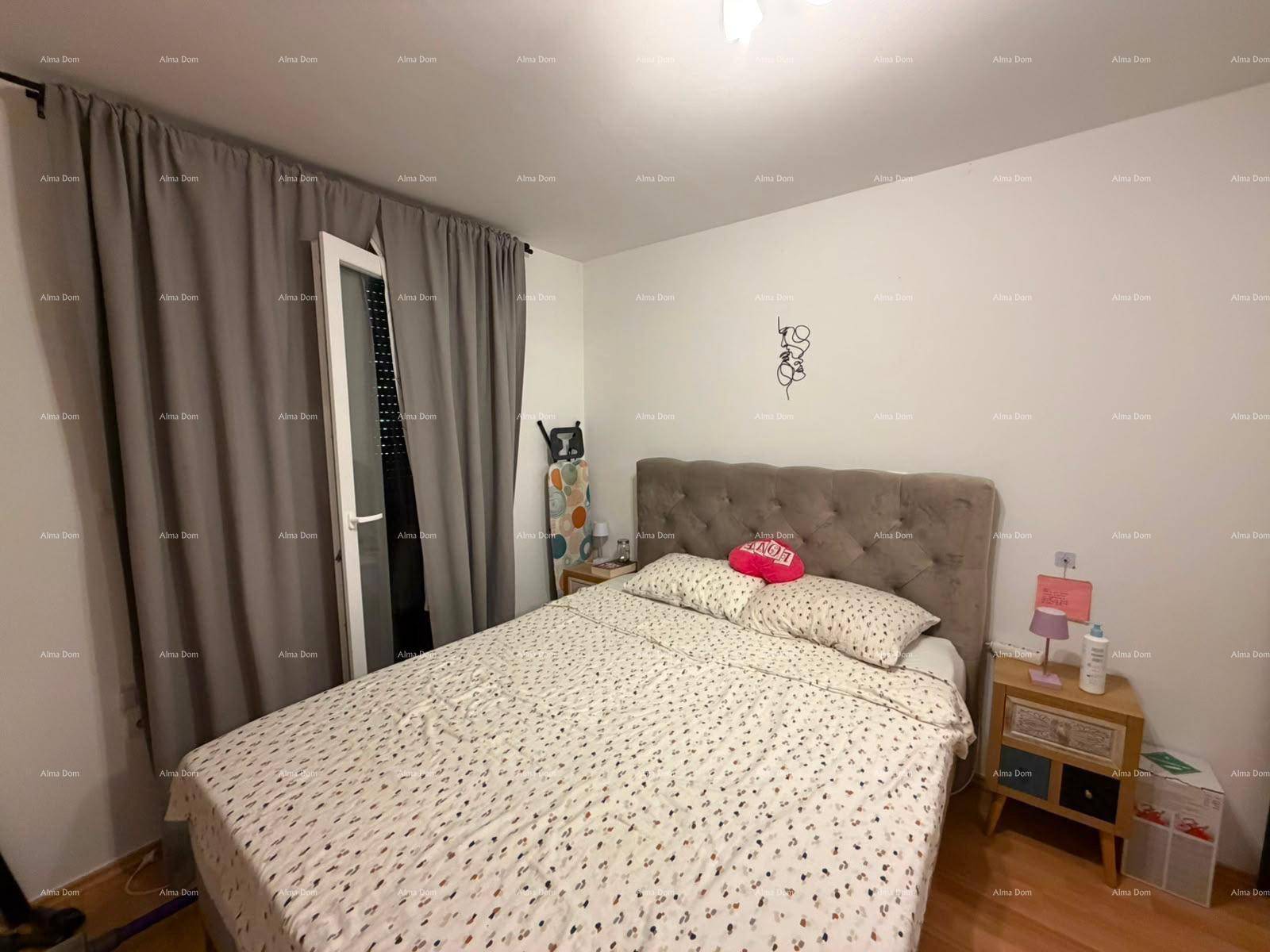 Gemütliches Schlafzimmer mit Doppelbett, Holzboden und Zugang zu einem Balkon.