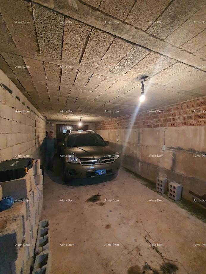 Geräumige Garage mit Betonwänden und einem geparkten Fahrzeug.