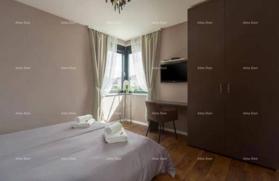 Helles Schlafzimmer mit Doppelbett, Schreibtisch und großem Fenster, das viel Tageslicht hereinlässt.