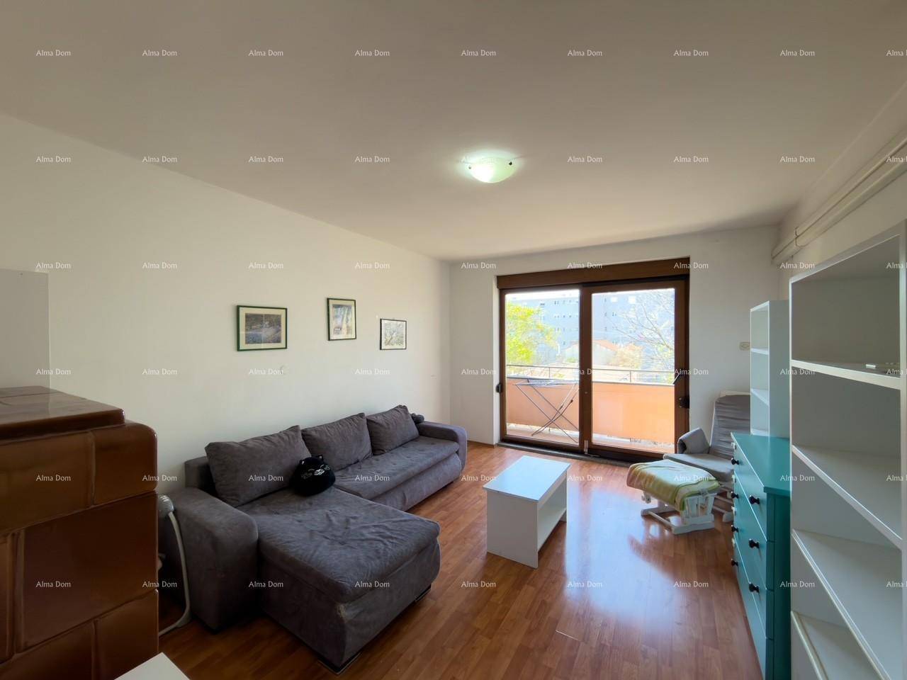 Helles Wohnzimmer mit Zugang zum Balkon, Holzfußboden und bequemer Couch.