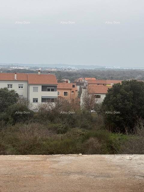 Weitblick über die umliegende Wohnsiedlung mit roten Dächern und grüner Landschaft unter bewölktem Himmel.