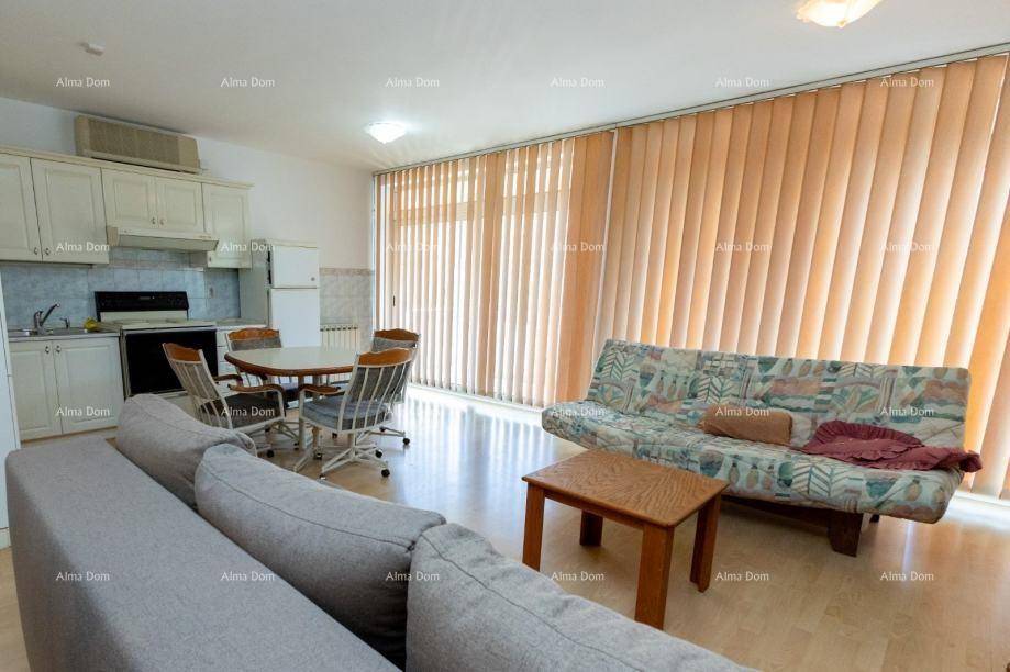 Heller Wohnbereich mit großen Fenstern, vertikalen Jalousien und gemütlichem Sofa.
