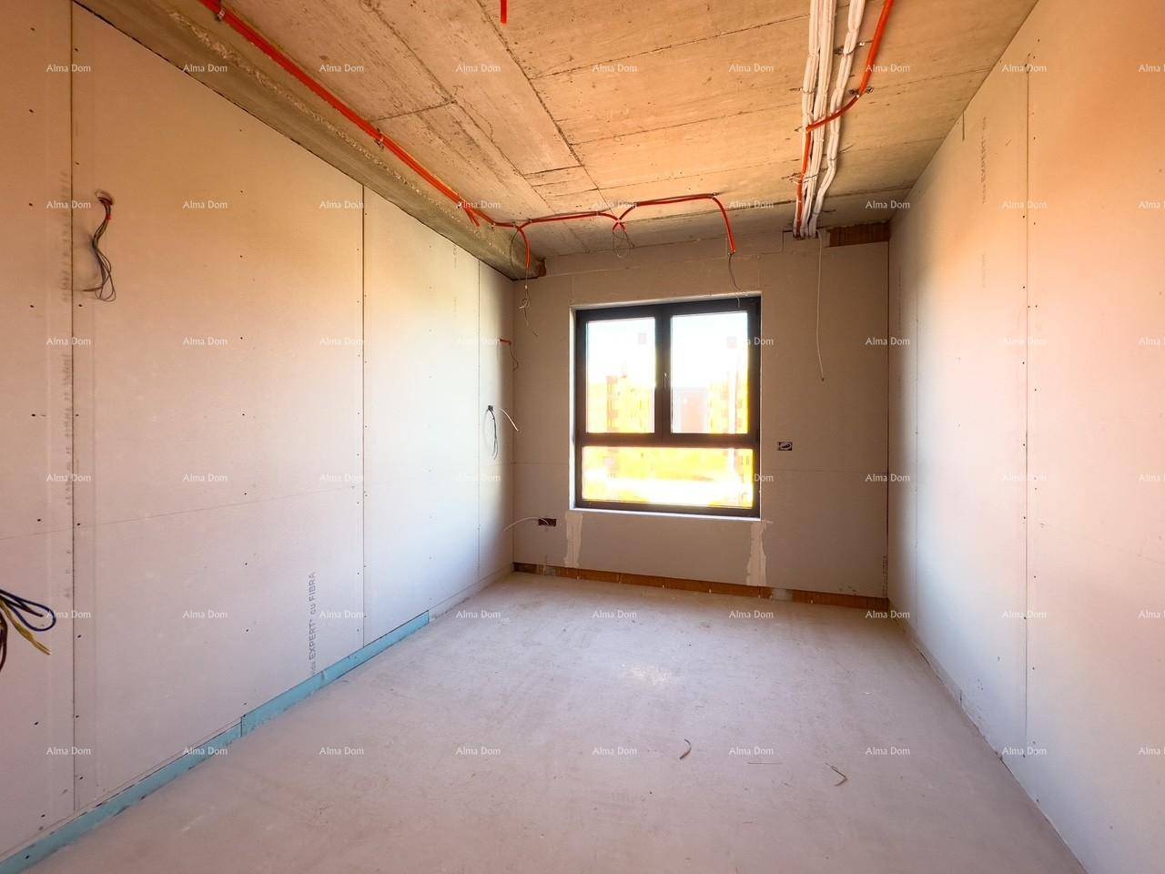 Schlafzimmer im Rohbau mit einem Fenster und sichtbaren Elektroinstallationen an der Betondecke.