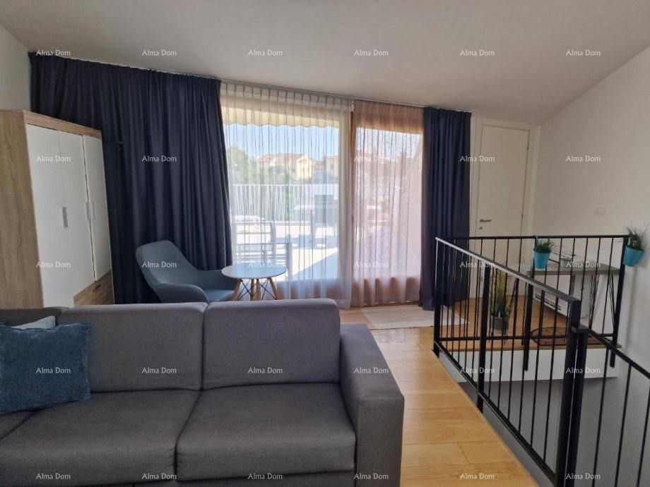 Gemütliches Wohnzimmer mit Sofa, Holzboden und Zugang zu einem Balkon.